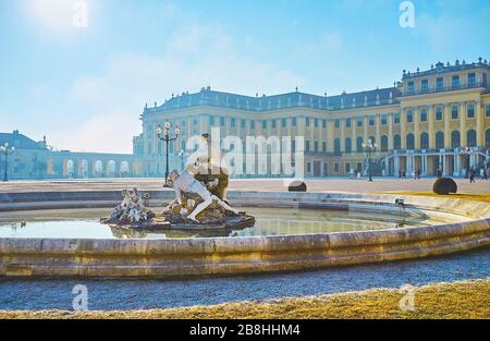 VIENNA, AUSTRIA - FEBRUARY 19, 2019: The facade of Baroque style Schonbrunn Palace with outstanding Ehrenhof fountain (Ehrenhofbrunnen) on the foregro Stock Photo