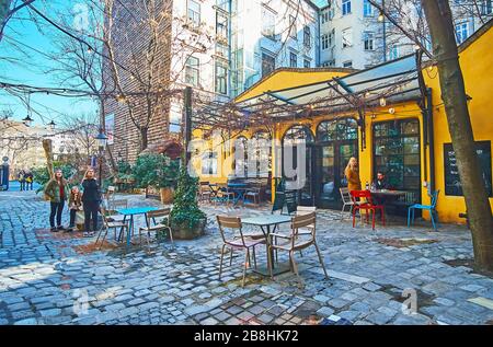 VIENNA, AUSTRIA - FEBRUARY 19, 2019: The small cafe in courtyard of Hundertwasser museum (Kunst Haus Wien), with shady terrace and small tables, on Fe Stock Photo