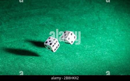 Playing casino games dice throw on a green table. Stock Photo