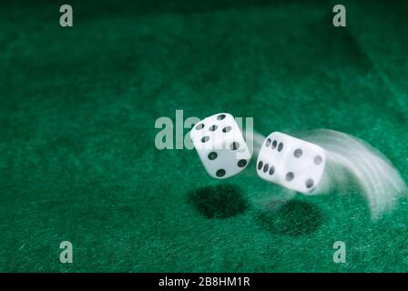 Playing casino games dice throw on a green table. Stock Photo