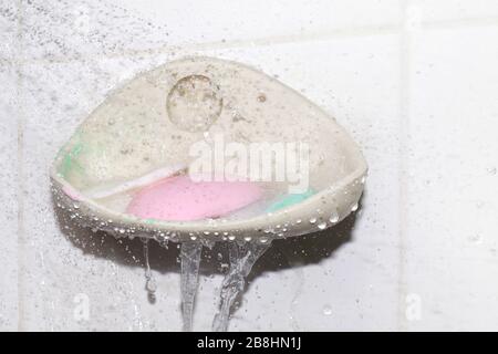 soap, water splash and soap bar on dish at wall, soap cubes used (selective focus) Stock Photo