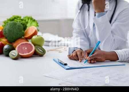 Cropped of nutritionist doctor writing diet plan Stock Photo