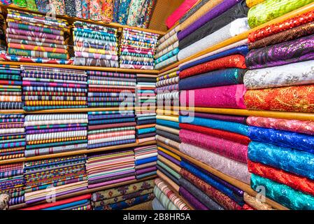 Colored textile or fabric at a street Asian Market, shelves with rolls of fabric and textiles Stock Photo