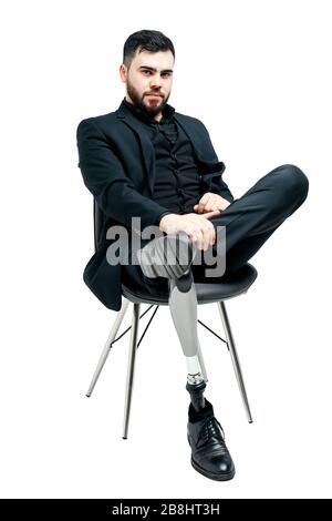 Disabled young man with prosthetic leg, artificial limb concept. Sitting on a chair, isolated on white background Stock Photo