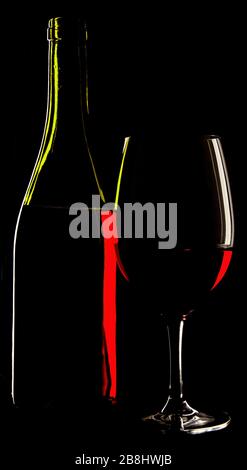 abstract view of a glass wine and the wine bottle against a solid black background. Stock Photo