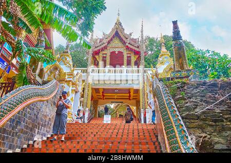 CHIANG MAI, THAILAND - MAY 7, 2019: The stunning relief and gilt gate of Wat Phra That Doi Suthep temple, located at the end of the long staircase on Stock Photo