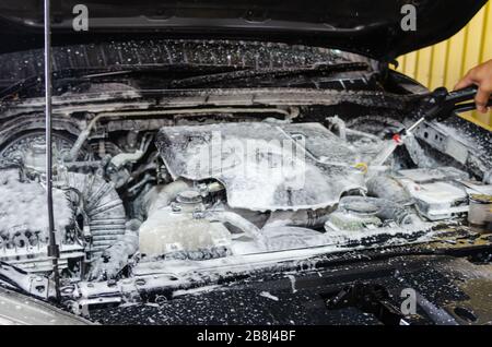 Car wash foam - engine cleaning with foam washing. Car maintenance details. Stock Photo