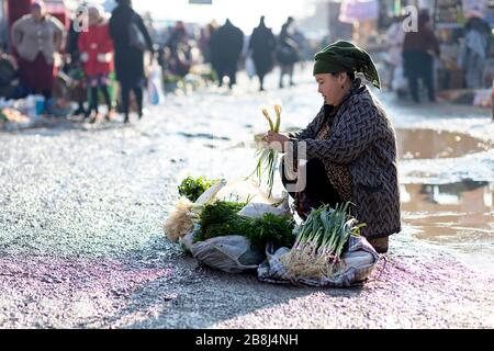 Woman selling small amount of vegetables at the Street Market, Khiva, Uzbekistan Stock Photo