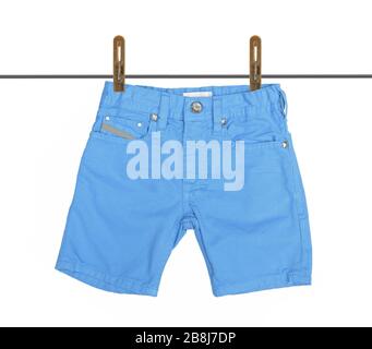 Blue jeans shorts with drying on clothesline isolated on the white background with clipping path. Stock Photo