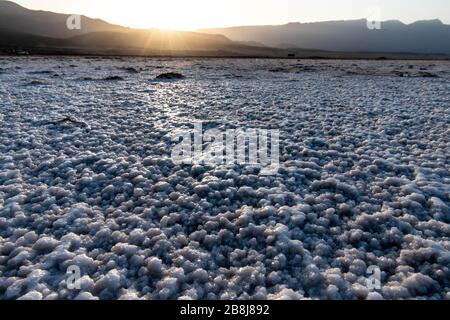 Africa, Djibouti, Lake Assal. Salt texture on the ground with mountains in the background Stock Photo