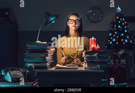 Angry frustrated woman working in the office late at night on Christmas Eve Stock Photo