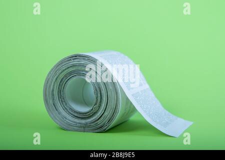 toilet paper made out of newspapers, alternative toilet paper, isolated on green, close-up, newspaper roll Stock Photo