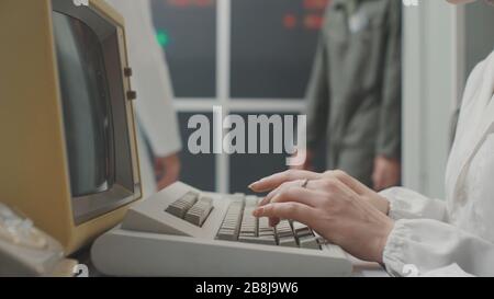 Woman working with an old vintage computer in a laboratory, data analysis and IT technology concept Stock Photo