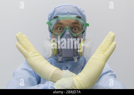 Man in chemical protective suit making stop gesture on white background.Focus on hands. Stock Photo