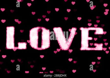blurred text pink LOVE sign LED Bokeh neon light pink on background bokeh lights heart soft colorful Stock Photo