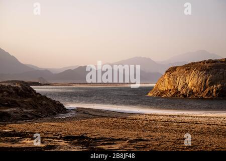 Africa, Djibouti, Lake Assal. Landscape view of lake Assal with mountains in the background. and a beach in the foreground. Stock Photo