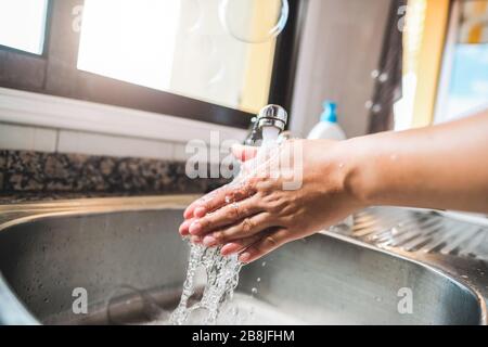 Woman washing her hands rubbing with soap for coronavirus prevention - Hygiene to stop spreading Covid 19 concept - Focus on hand Stock Photo