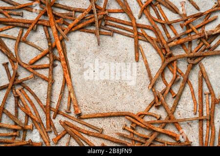 Rusty used nails on a cement metal background Stock Photo