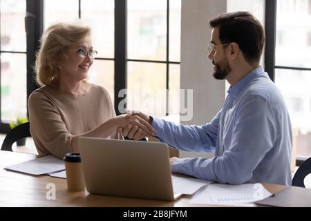 Happy businesspeople shake hands closing deal at meeting Stock Photo