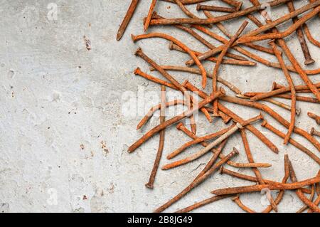 Rusty used nails on a cement metal background Stock Photo