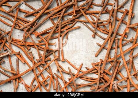 Rusty used nails on a cement metal background Stock Photo