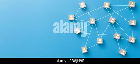 Wooden blocks connected together on blue background. Teamwork, network and community concept. Stock Photo