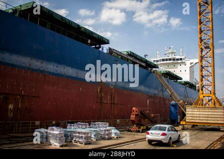 A large tanker cargo ship is being renovated and painted in shipyard dry dock Stock Photo