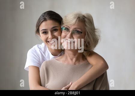 Smiling middle-aged mother and adult daughter hugging Stock Photo