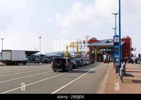 Dagebüll, Germany - March 5, 2020: Panoramic view of the ferry terminal at low tide, ferry UTHLANDE moored, cars waiting in line. Stock Photo