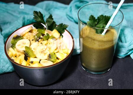 Superfood, a peel of fruit with chopped almonds on black background, kiwi, banana, apple and ginger Stock Photo