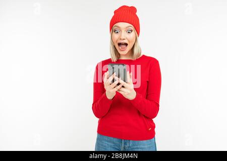 surprised girl with a smartphone in hands on a background with copy space Stock Photo