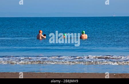 Portobello, Edinburgh, Scotland, UK. 22nd Mar, 2020. Sunshine and blue skies with an early morning temperature of 2 degrees centigrade rising to 8 degrees by noon. A variety of people out on the beach relaxing and enjoying activities to get away from the television and radio. Stock Photo