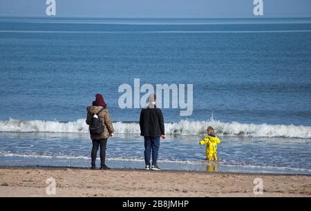 Portobello, Edinburgh, Scotland, UK. 22nd Mar, 2020. Sunshine and blue skies with an early morning temperature of 2 degrees centigrade rising to 8 degrees by noon. A variety of people out on the beach relaxing and enjoying activities to get away from the television and radio. Stock Photo