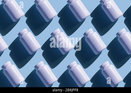 Repeating white cans of pills on a blue background, background in pop art style, medical concept Stock Photo