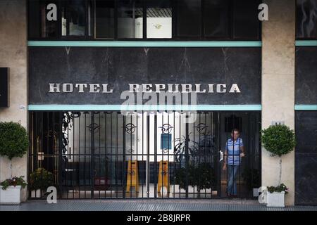 Buenos Aires, Argentina - March 21, 2020: Unidentified person  standing in the entrance of his hotel illustrating the suffering of the business econom Stock Photo