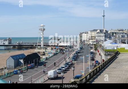 Brighton UK 22nd March 2020 - Visitors enjoy some Spring sunshine today along  Brighton seafront which looks quiet this lunchtime during the Coronavirus COVID-19 pandemic crisis . Credit: Simon Dack / Alamy Live News Stock Photo