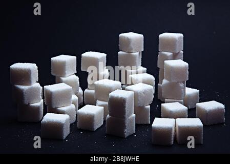 Pile or chart of sugar cubes on a black background. Stock Photo