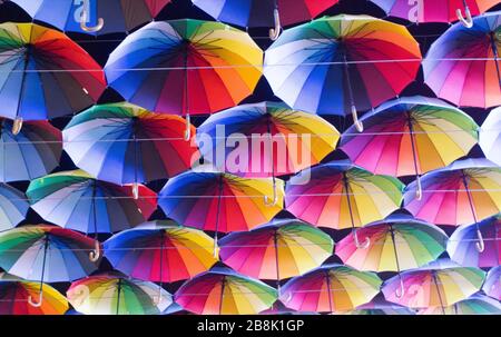 Many colorful umbrellas strung across the street. Stock Photo