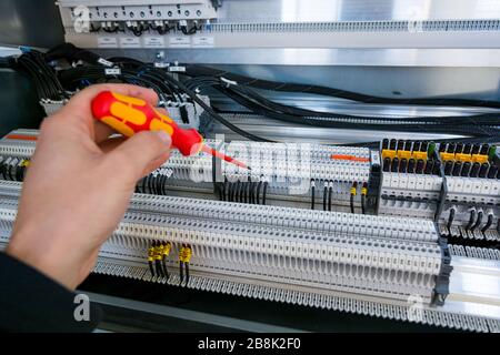 Installing a new connector in electric cubicle. Stock Photo