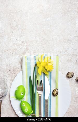 Beautiful festive or Easter table setting with spring flowers and eggs on light textured background. Top view with copy space. Stock Photo