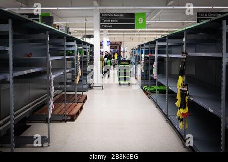 Manchester, UK. 21st Mar, 2020. Toilet roll shelves left empty as an employee try to replenish with the few rolls left in the shop. Credit: Andy Barton/Alamy Live News Stock Photo