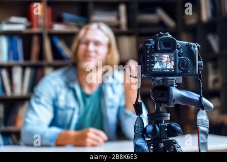 Professional digital dslr camera on tripod film video of man blogger. Stock Photo