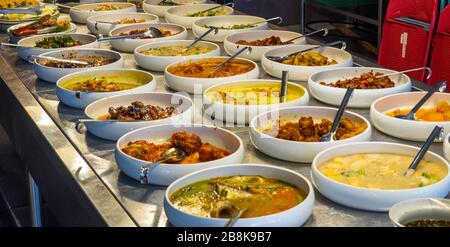 Buffet selection of Malay and Indian dishes on a stainless steel benchtop in an Indian restaurant Kuala Lumpur. Stock Photo