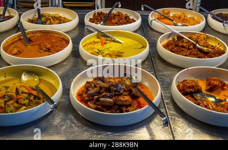 Buffet selection of Malay and Indian dishes on a stainless steel benchtop in an Indian restaurant Kuala Lumpur. Stock Photo