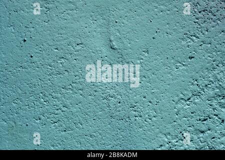 texture of a painted wall. cement plate light aquamarine color background. wall with bumps and small pits. Stock Photo