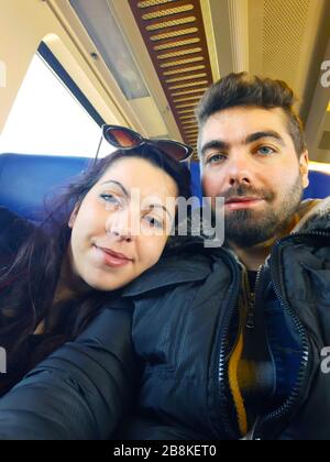 couple of young travelers in love tourists traveling on a train together in amsterdam Stock Photo