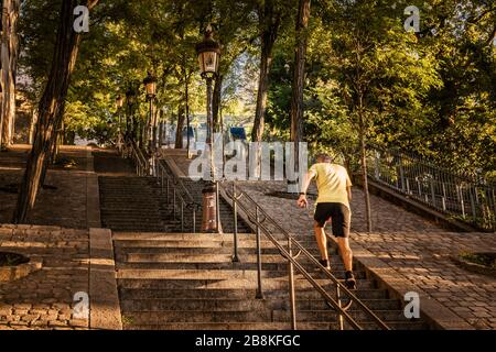 Jogger running up the steps of Montmartre Hill on a beautiful sunny morning in Paris, France Stock Photo