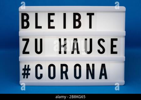 is written on an illuminated panel with black letters: Stay at home #Corona Stock Photo