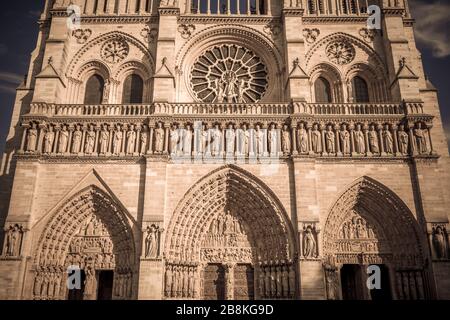 Detail of the Notre Dame Cathedral facade stone work and rose window on a sunny autumn afternoon Stock Photo