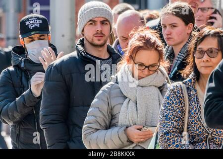 Some of the queue wear protective masks and gloves but there is still little sense that 'social distancing' is vital - Waitrose at Clapham Junction is only open to NHS workers and the over 70's for the first hour so a queue of regular customers waits outside - Anti Coronavirus (Covid 19) outbreak in London. Credit: Guy Bell/Alamy Live News Stock Photo